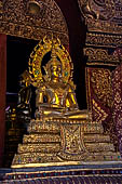 Chiang Mai - The Wat Phra Singh temple. The ubosot (ordination hall). Detail of the ku, a large ornate Buddha throne that sits in the middle of the building. 